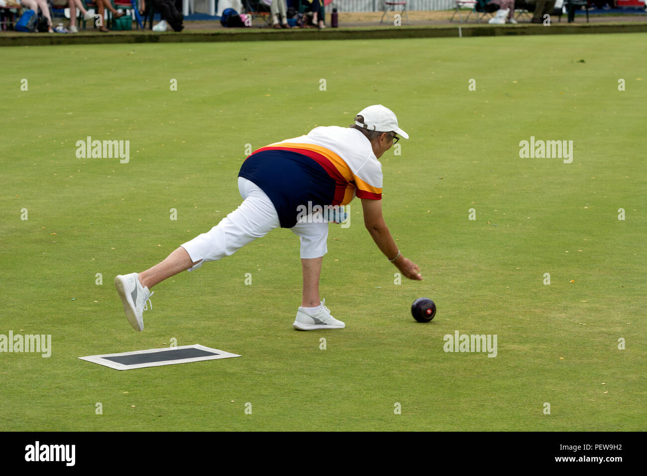 A player bowling a wood at the national women`s lawn bowls